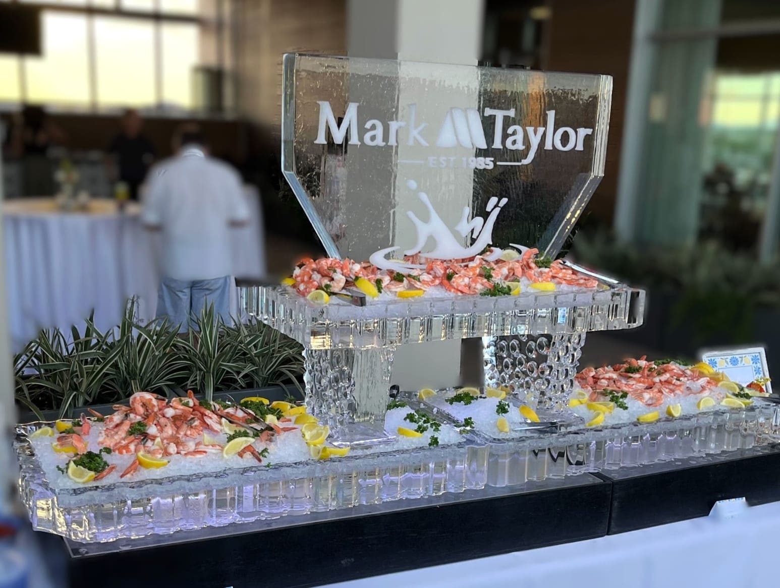Carved ice sculpture and chilled seafood display at a corporate reception