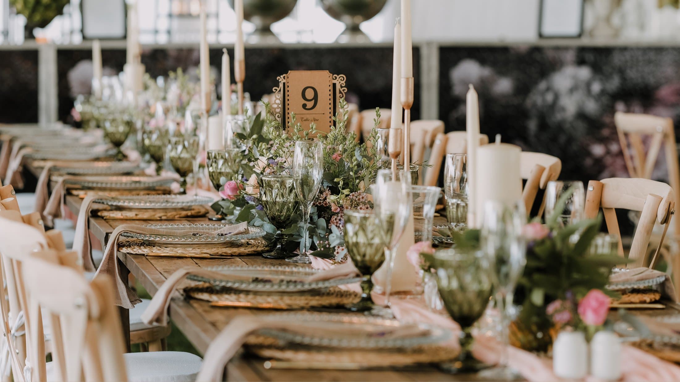 Outdoor wedding reception table at golden hour with candles, eucalyptus, and a peach runner