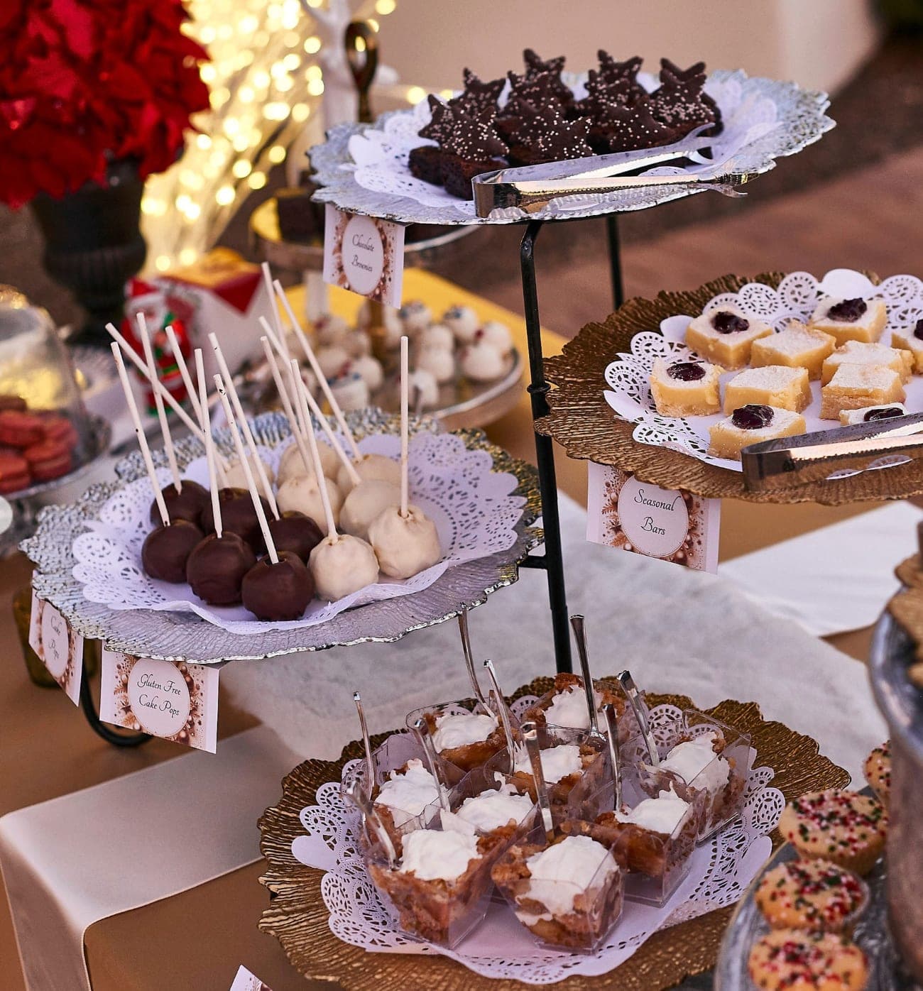 A tiered holiday dessert display with cookies, cake pops, seasonal bars, and mini desserts